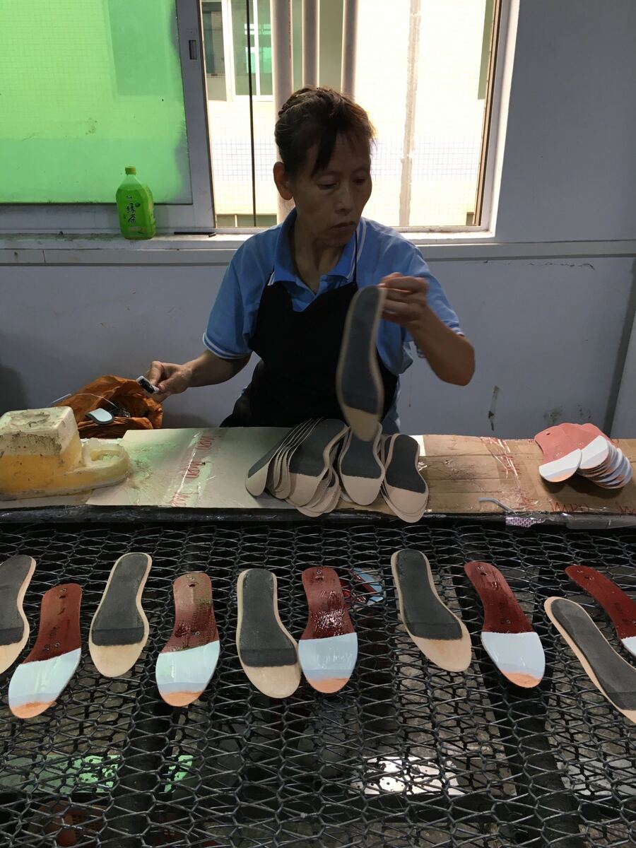Worker applying glue to shoe soles, Dongguan factory fieldwork