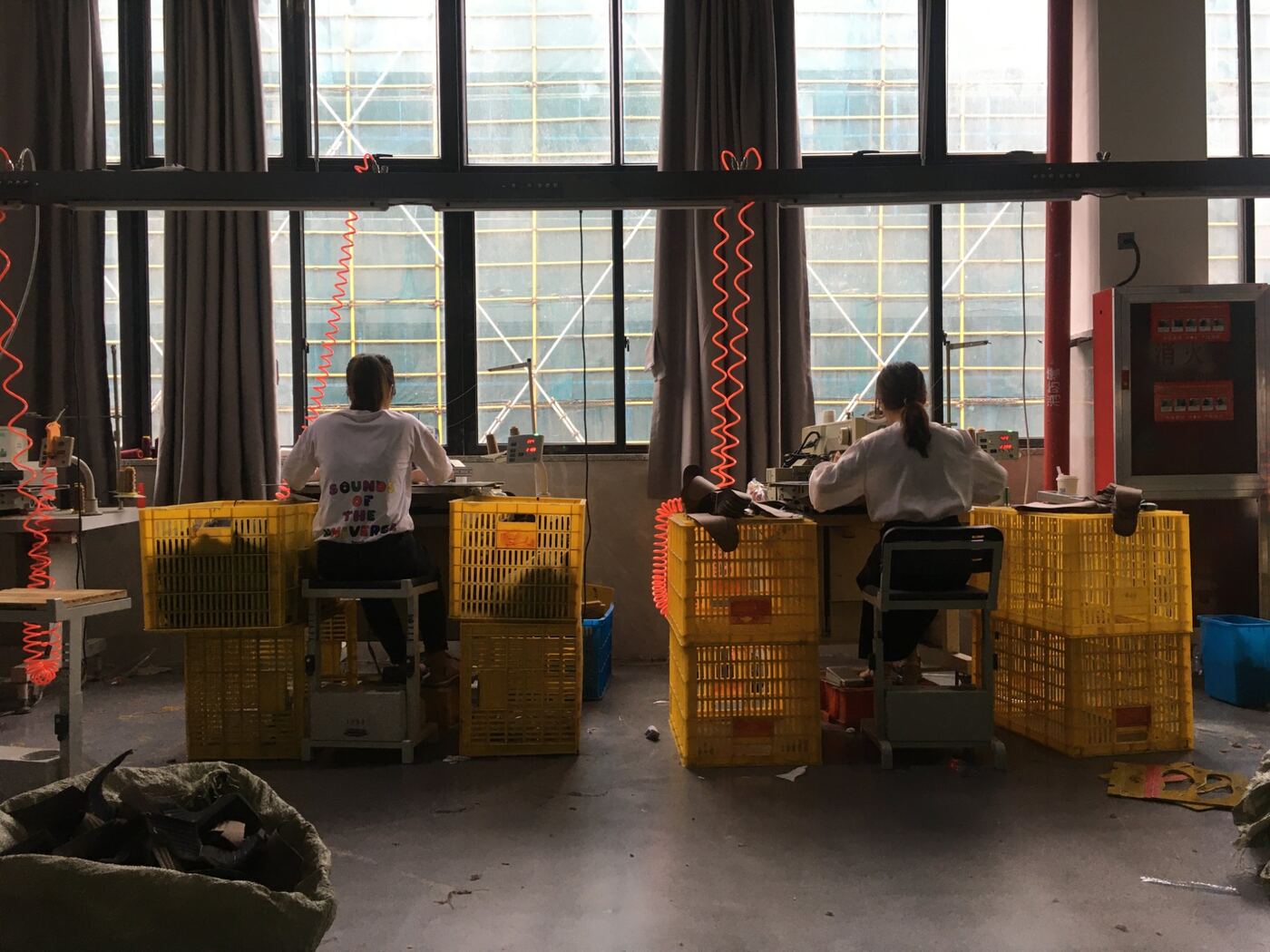 Two workers at stitching machines, factory floor, Pearl River Delta